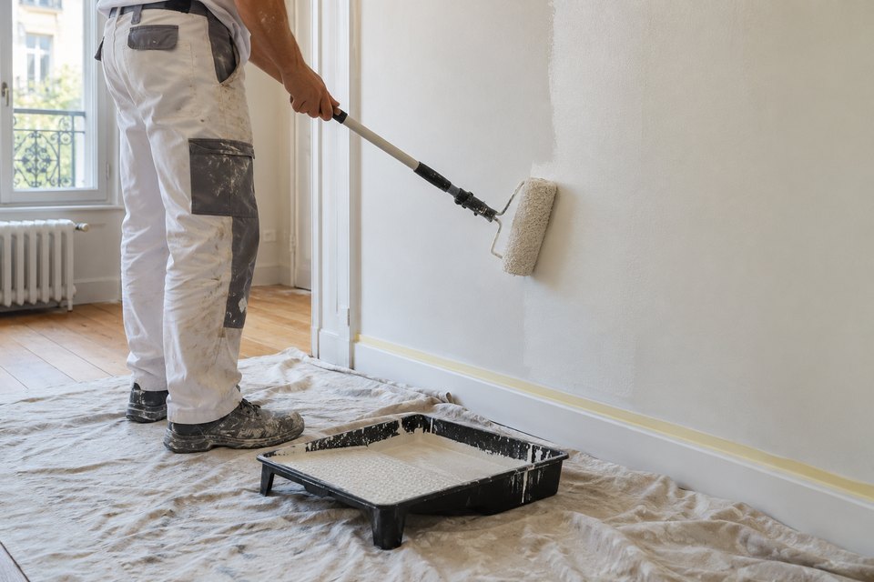 Peintre passant un rouleau sur un mur intérieur